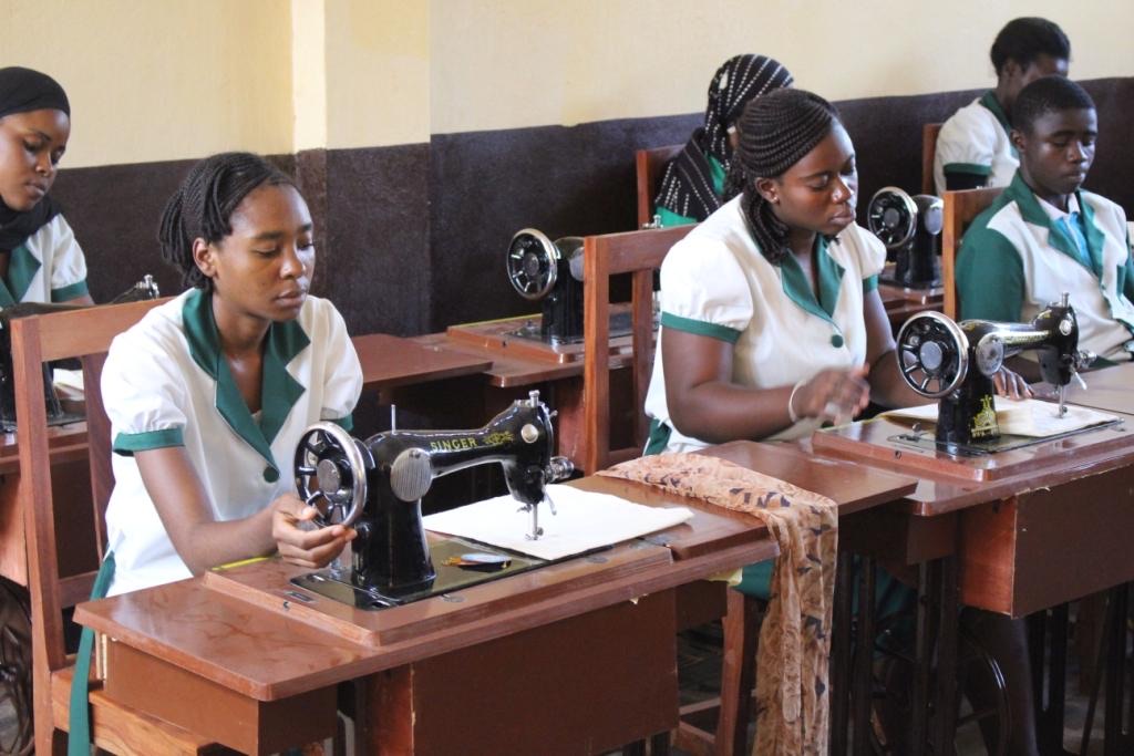 Trainees at sewing machines in a tailoring workshop